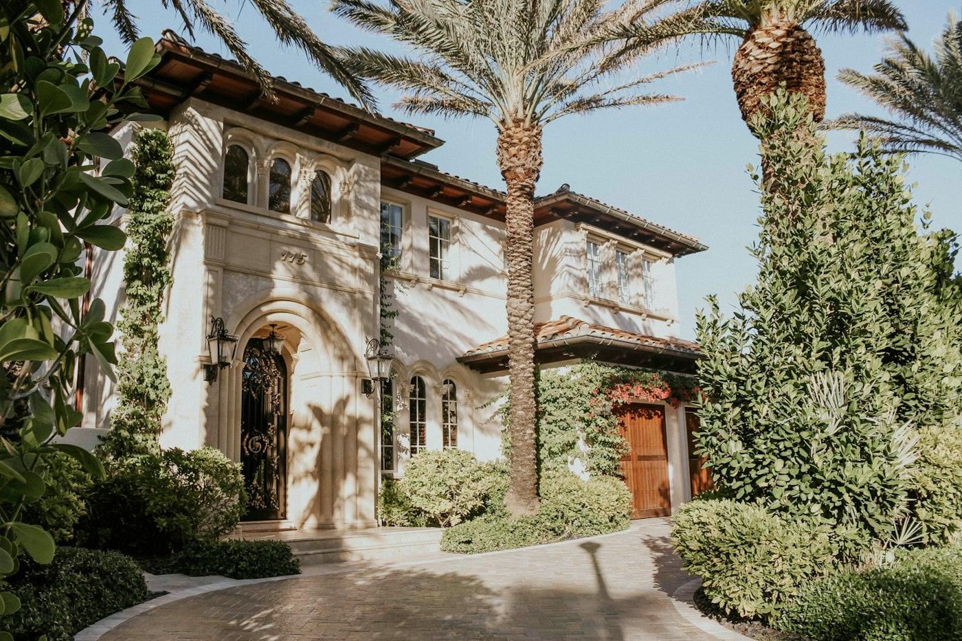 Mediterranean-style South Florida home surrounded by palms